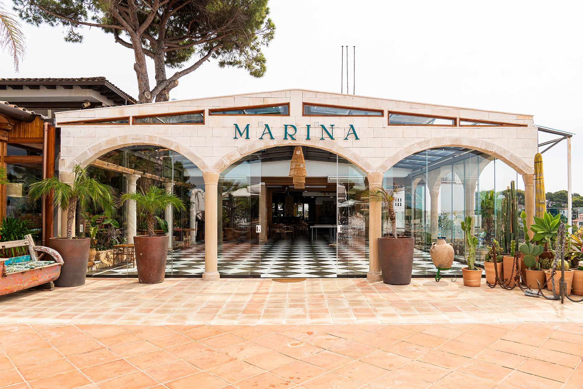 Entrée de Marina Roger De Flor By Seleqtta avec arches, palmiers et cactus.