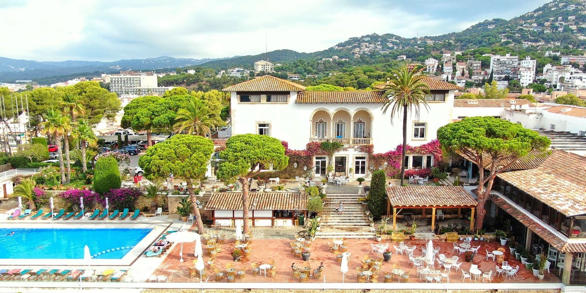 a large white building with a swimming pool in front of it