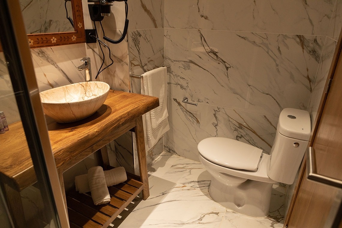 un baño con un inodoro y un lavabo de madera