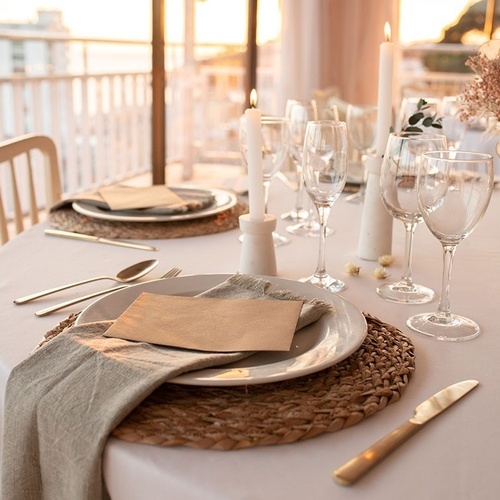 una mesa con platos , copas de vino , servilletas y cubiertos