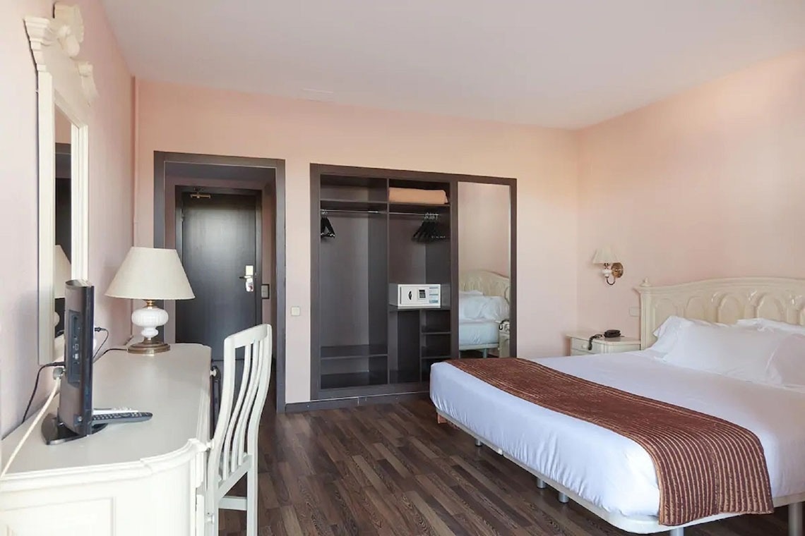 una habitación de hotel con una cama y un escritorio