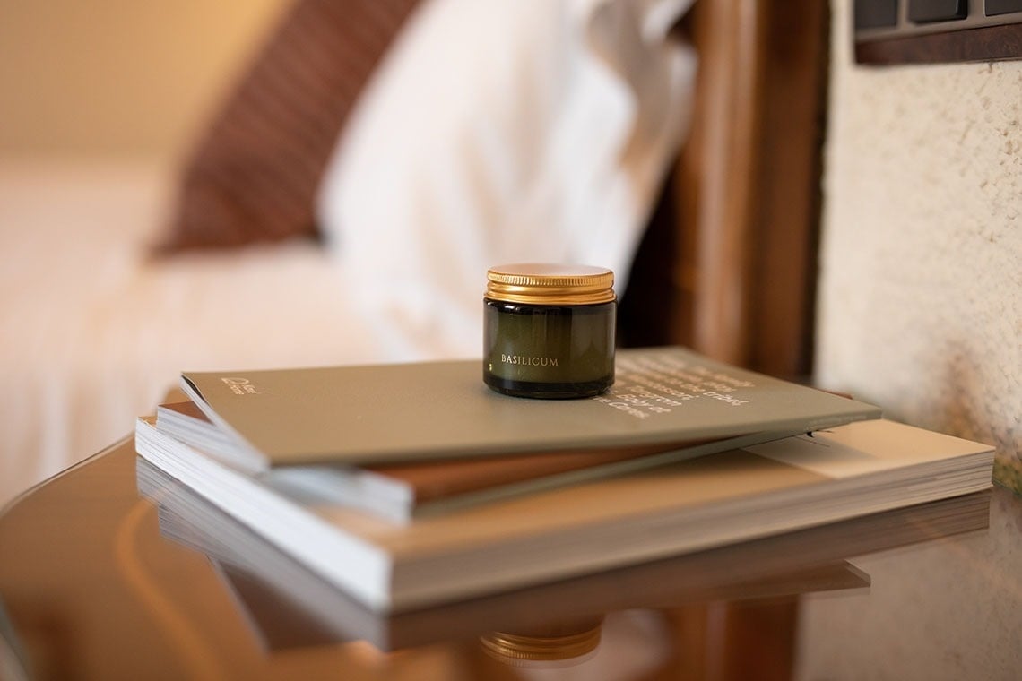 un frasco de eau de parfum se sienta encima de una pila de libros