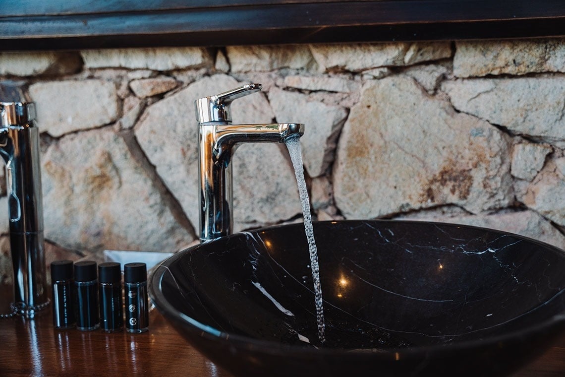 Un fregadero de mármol negro con grifo cromado