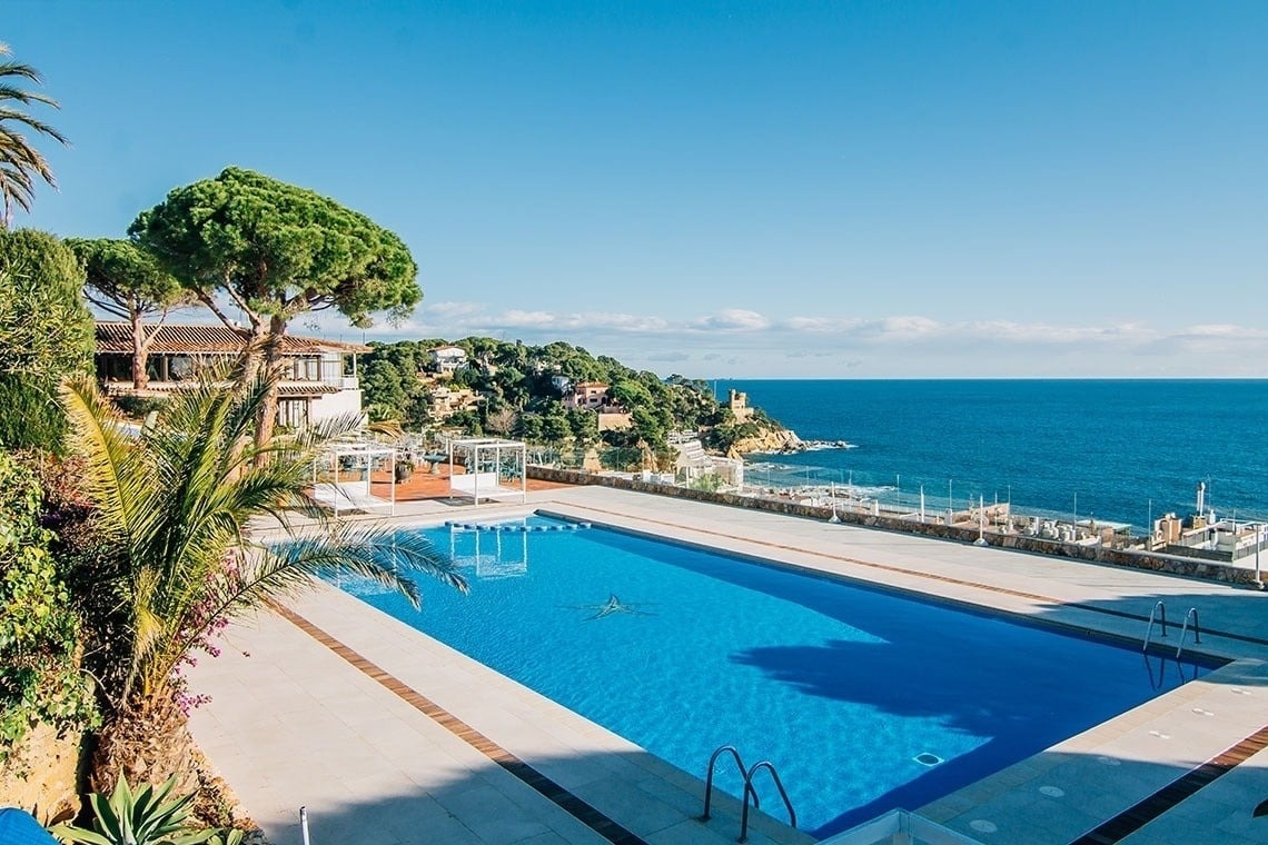 a bar with stools and bottles of liquor on shelves