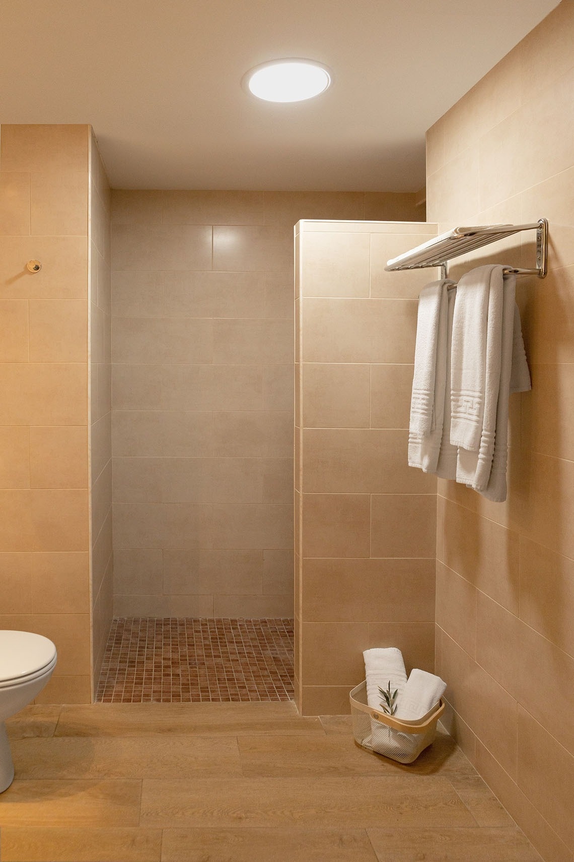 un baño con una ducha y una canasta de toallas