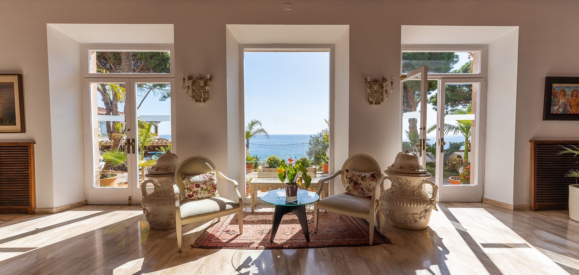 a room with two chairs and a table with a view of the ocean