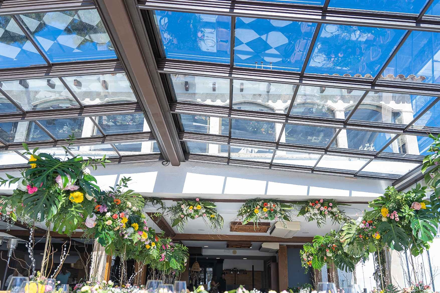 Glass-roofed event room with floral decor at Roger De Flor By Seleqtta.
