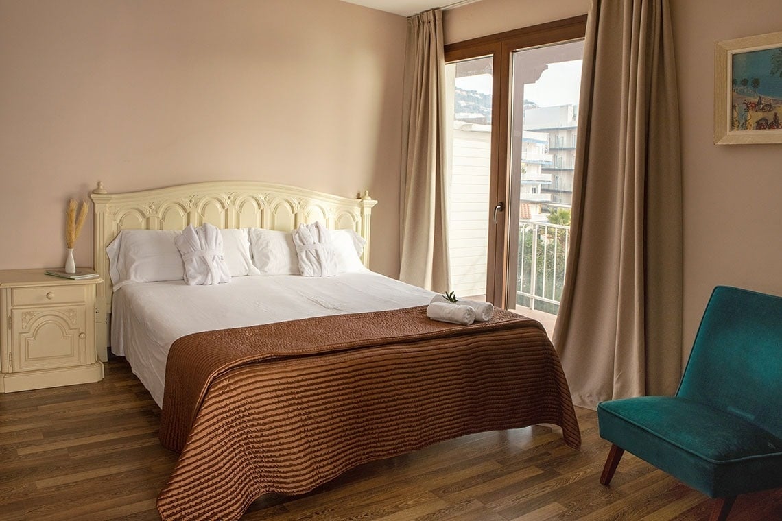 una habitación con una cama y una silla y una ventana