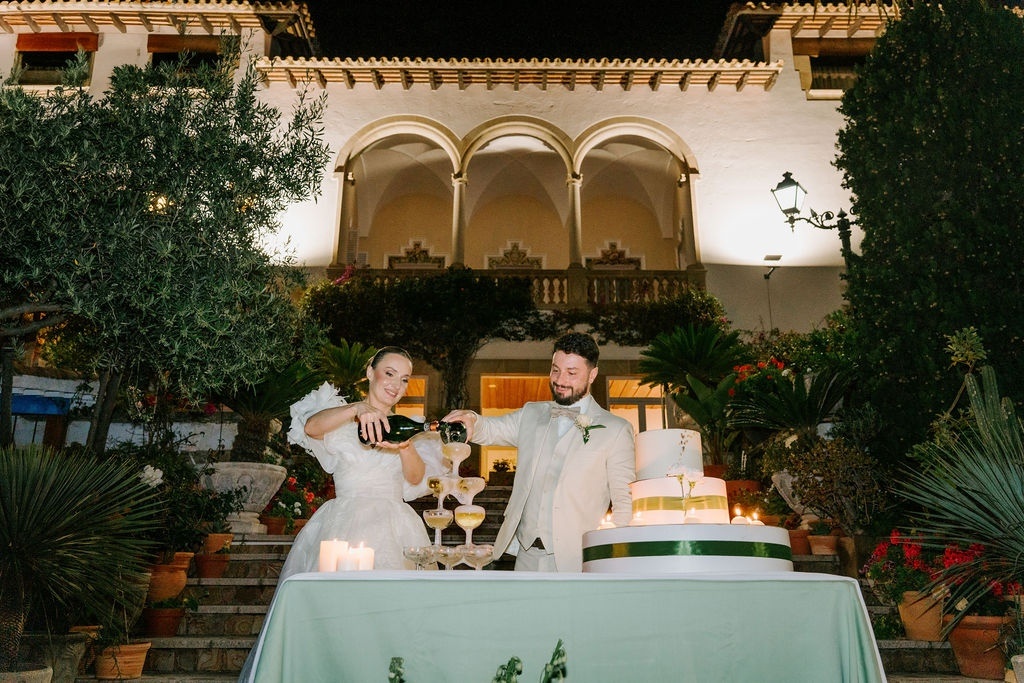 Newlyweds pouring champagne at Roger De Flor By Seleqtta.