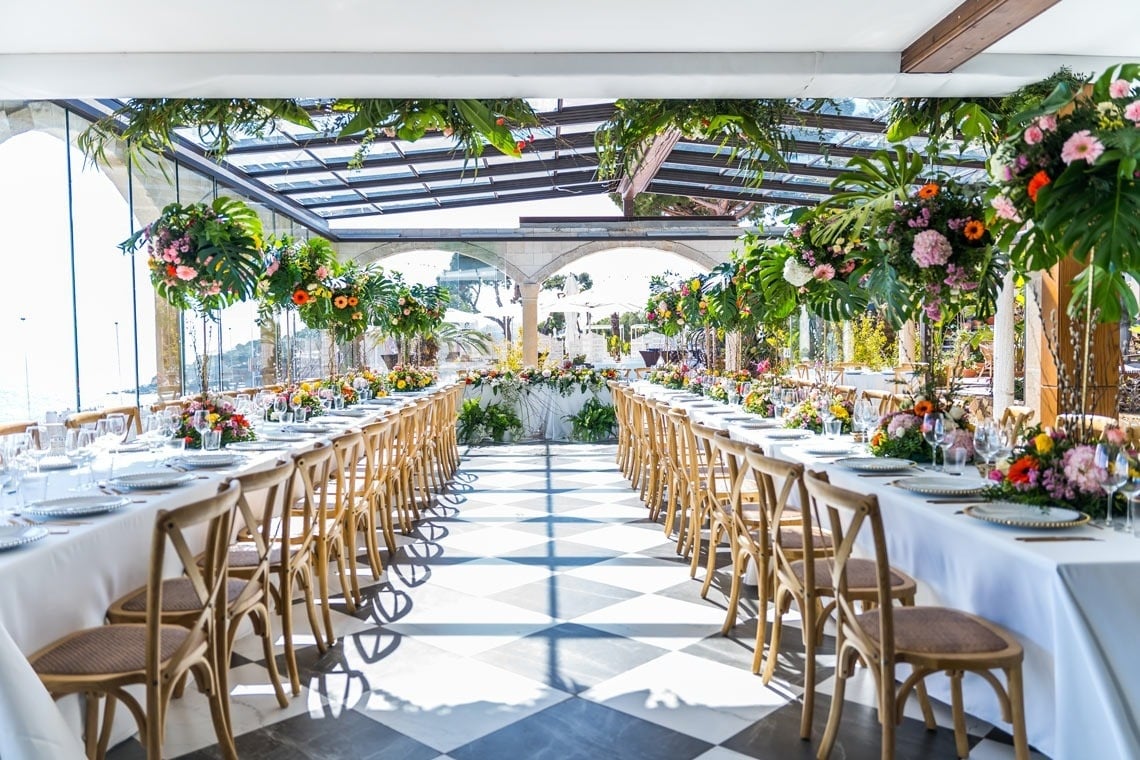 una mesa larga está decorada con platos y copas de vino