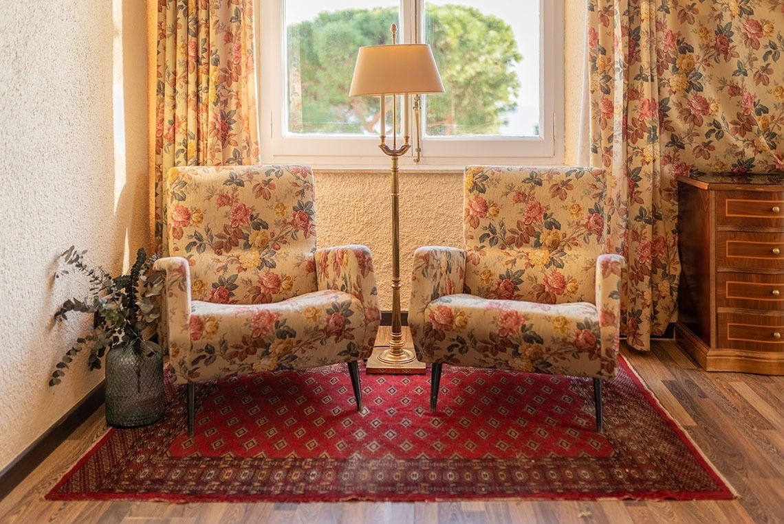 dos sillas florales y una lámpara en una habitación