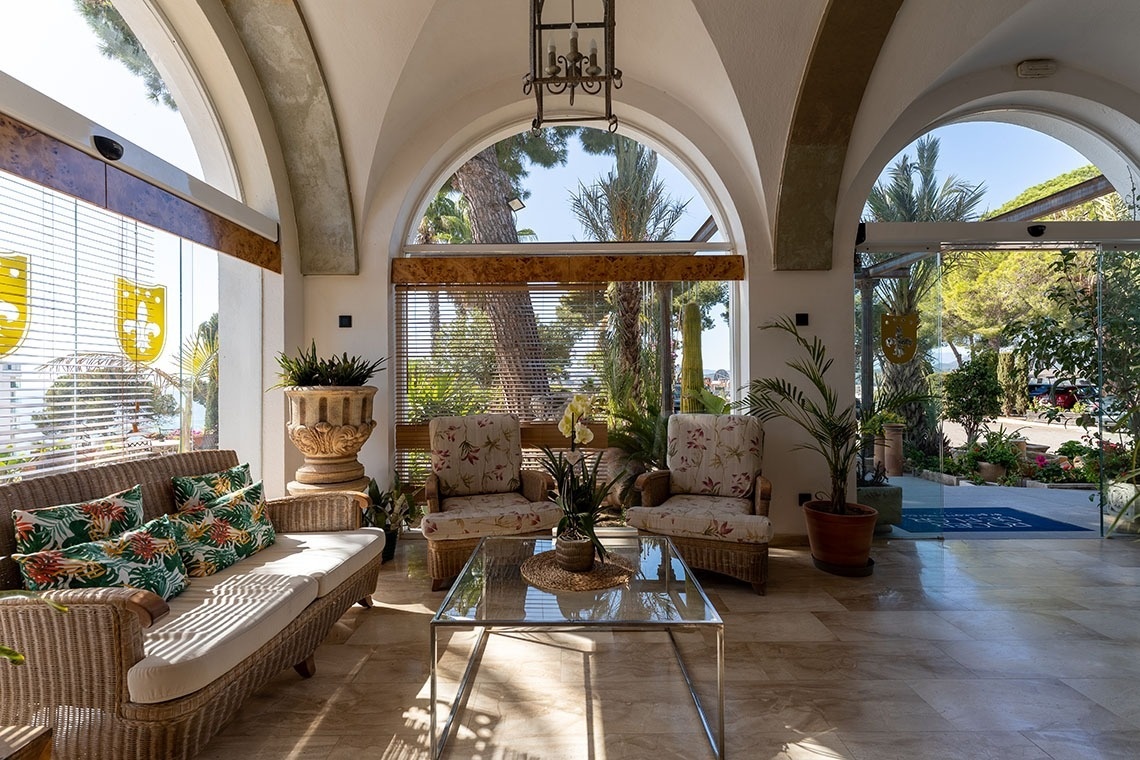 a living room with a couch and chairs and a glass table