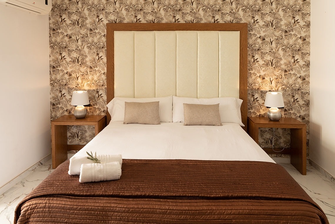 un dormitorio con una cama y dos mesitas de noche