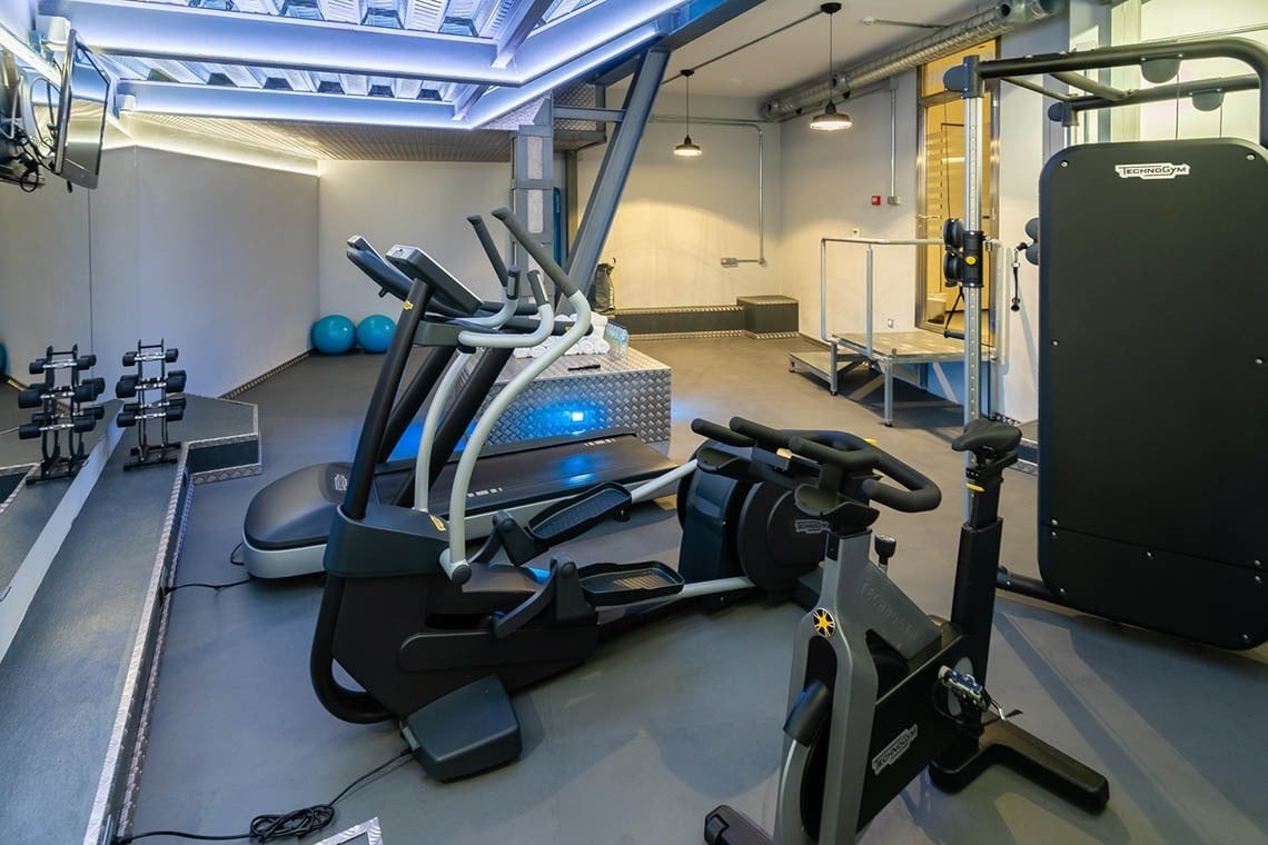 a gym with a treadmill that says technogym on it
