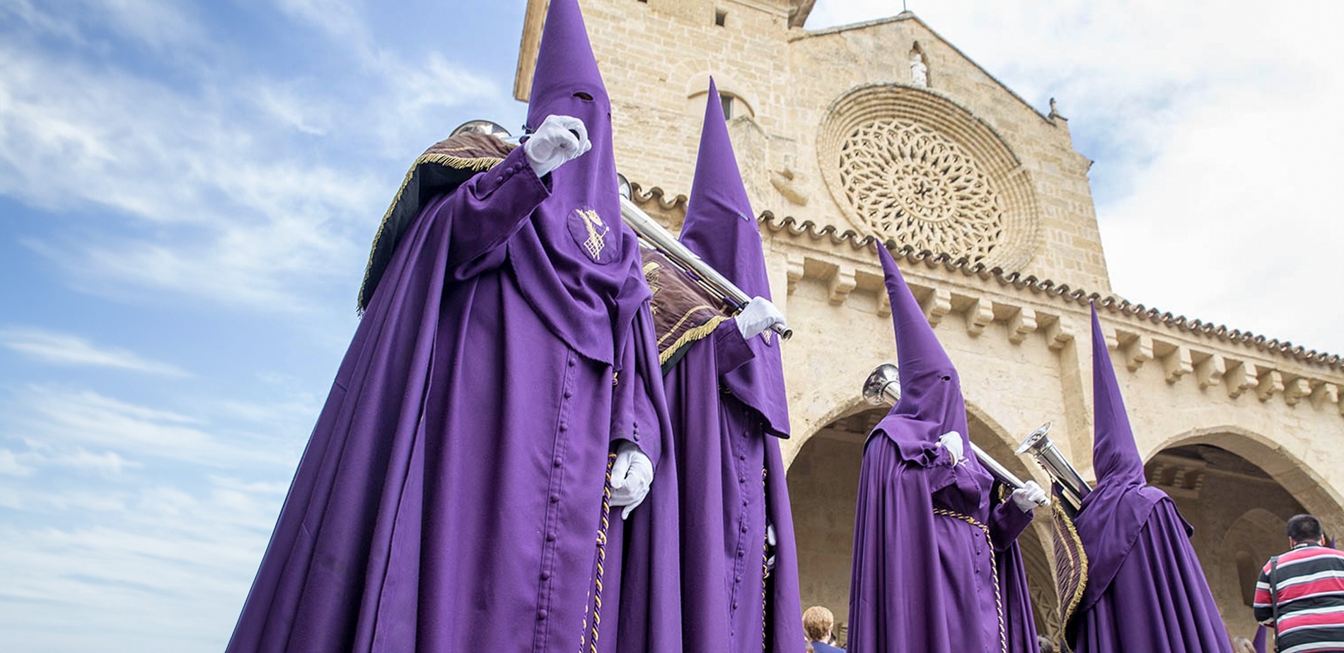 un grupo de personas con trajes morados están paradas frente a una iglesia