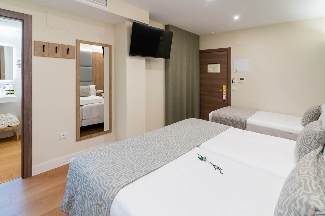 una habitación de hotel con dos camas y un escritorio