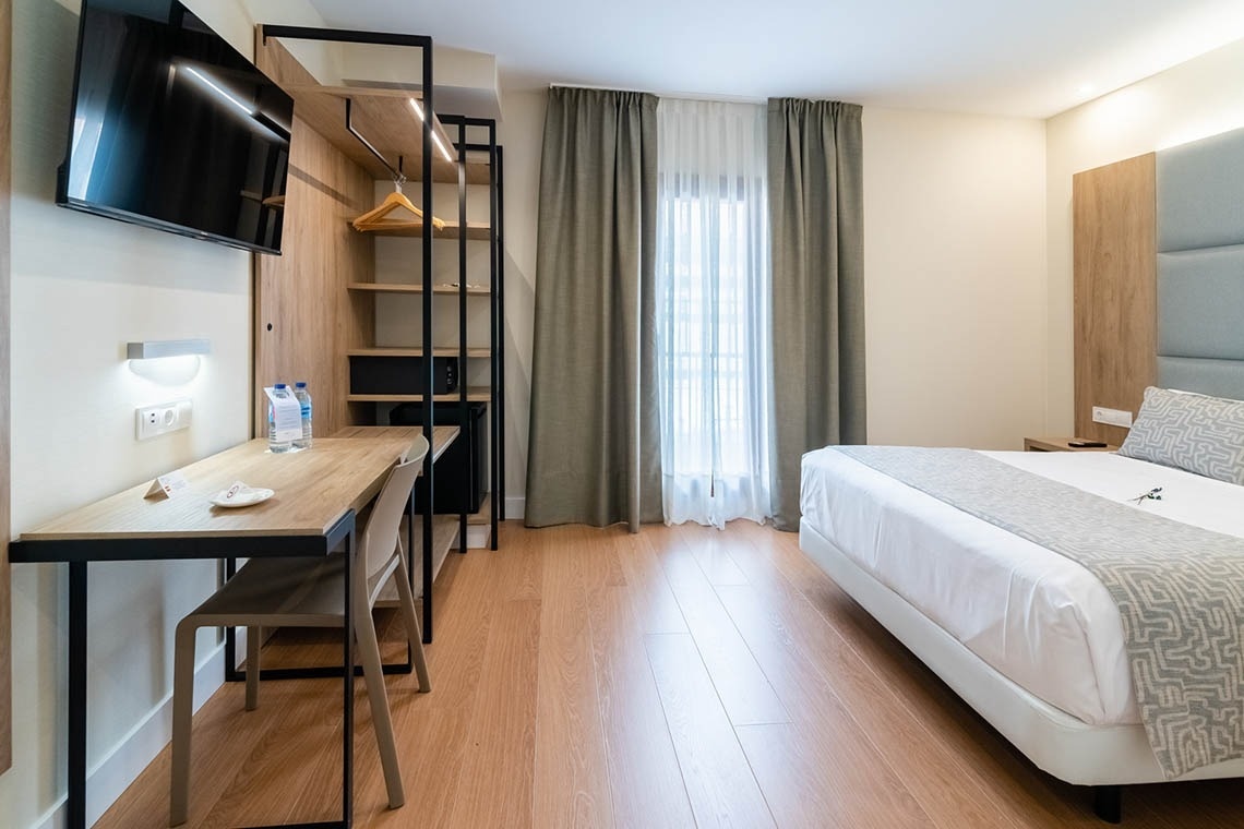 una habitación de hotel con una cama y un escritorio
