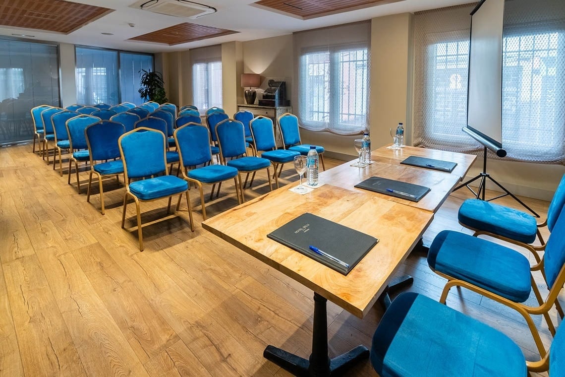 una sala de conferencias con mesas y sillas azules