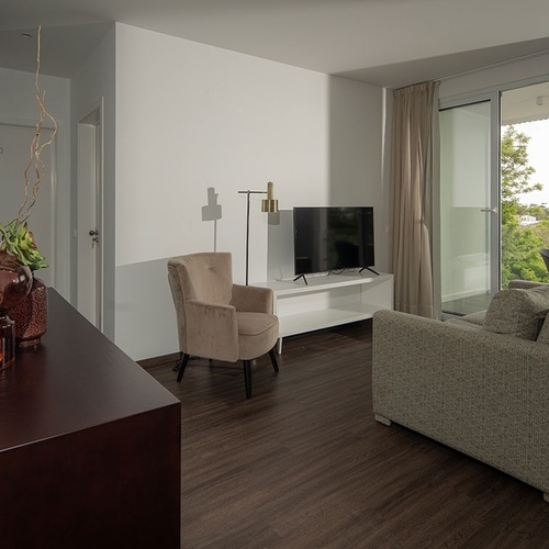 a living room with a couch a chair and a flat screen tv