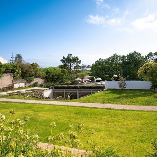a lush green field with a white building in the background