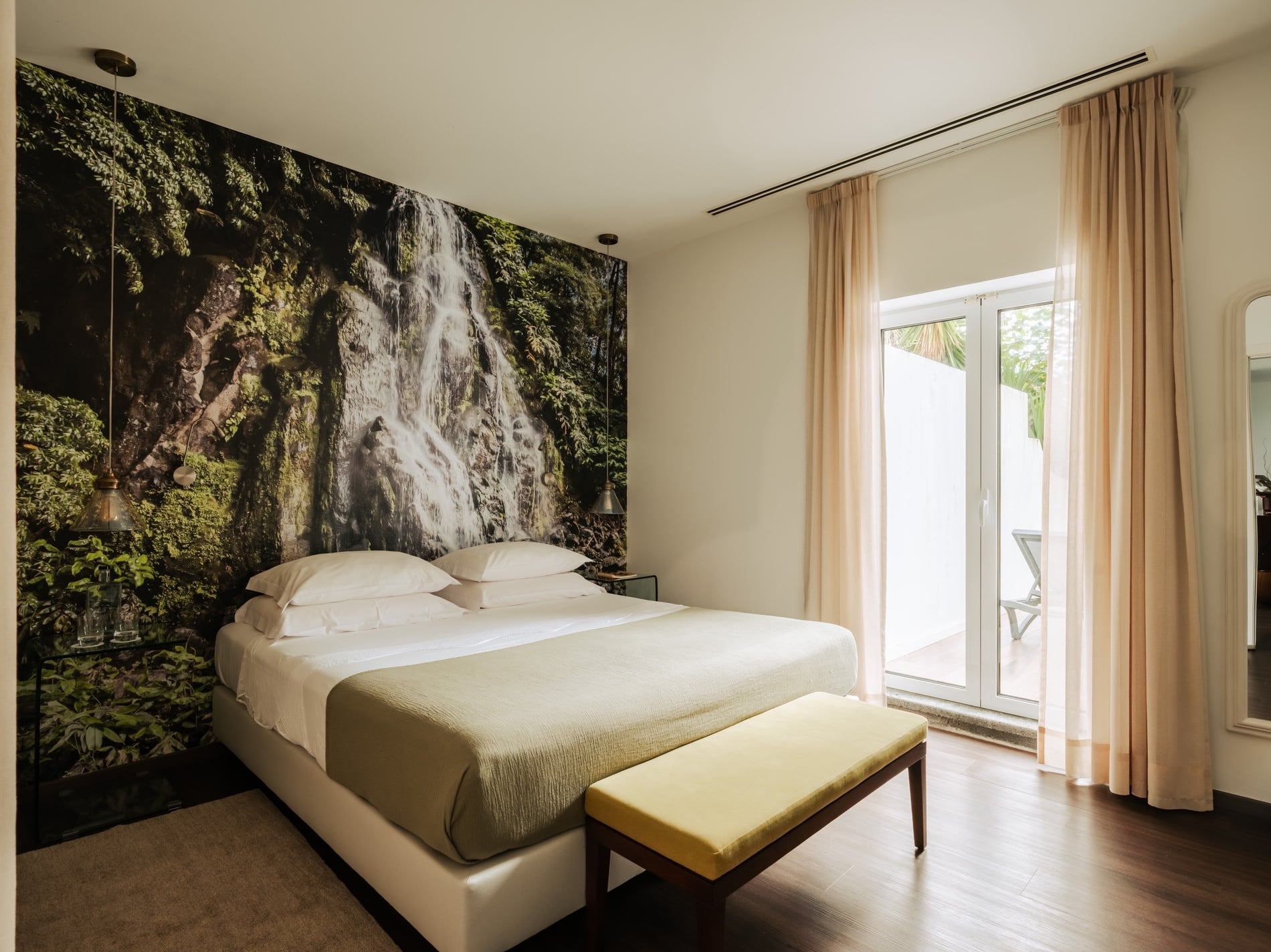 Dormitorio con cama de matrimonio y foto de una cascada en la pared sobre la cama.