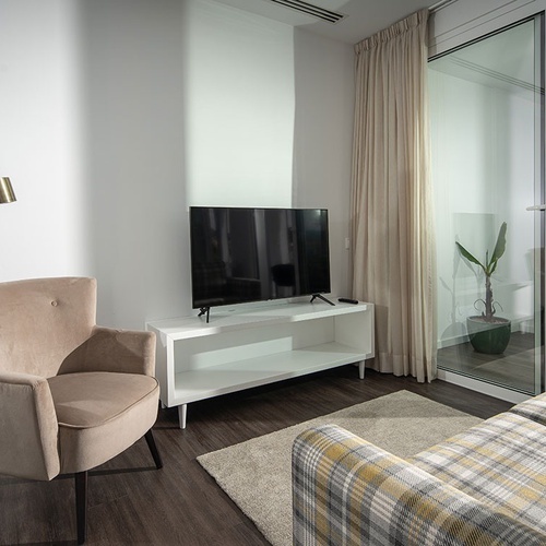 a living room with a couch a chair and a flat screen tv