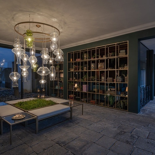 a hallway with a shelf full of books and a chandelier hanging from the ceiling