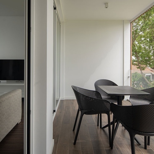 a balcony with a table and chairs and a flat screen tv