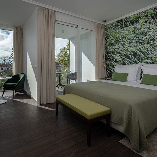 a hotel room with a large bed and green pillows