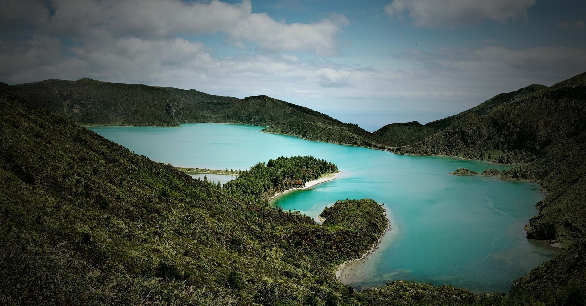a small island in the middle of a lake surrounded by mountains