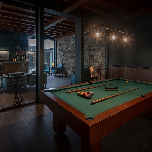 a pool table in a dark room with a glass wall