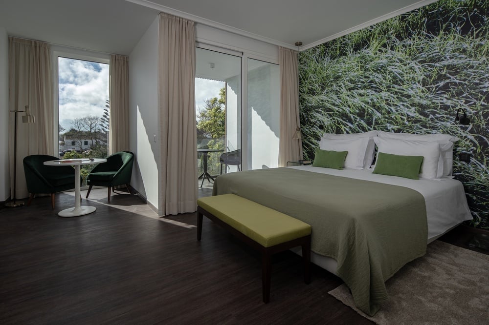 a hotel room with a large bed and green pillows