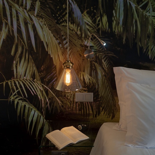 an open book sits on a nightstand in front of a palm tree wallpaper