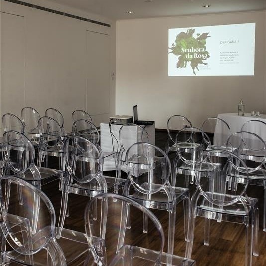 uma sala de jantar com mesas e cadeiras brancas