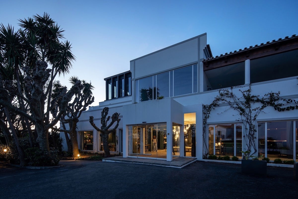 una gran casa blanca con muchas ventanas y palmeras alrededor