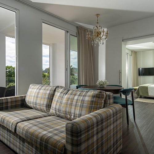a living room with a plaid couch and a chandelier