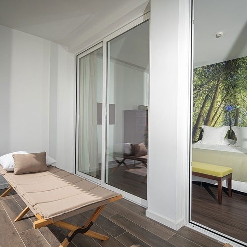 a bedroom with a painting of trees on the wall