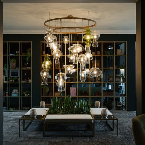 a hallway with a shelf full of books and a chandelier hanging from the ceiling