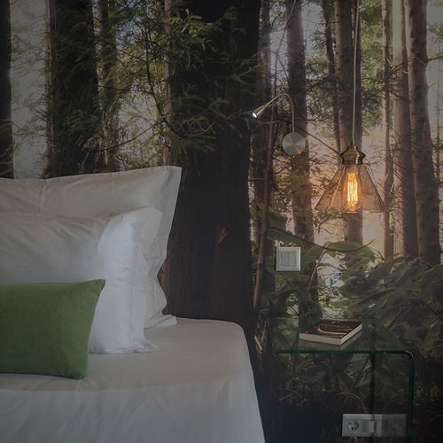 a bedroom with a picture of trees on the wall