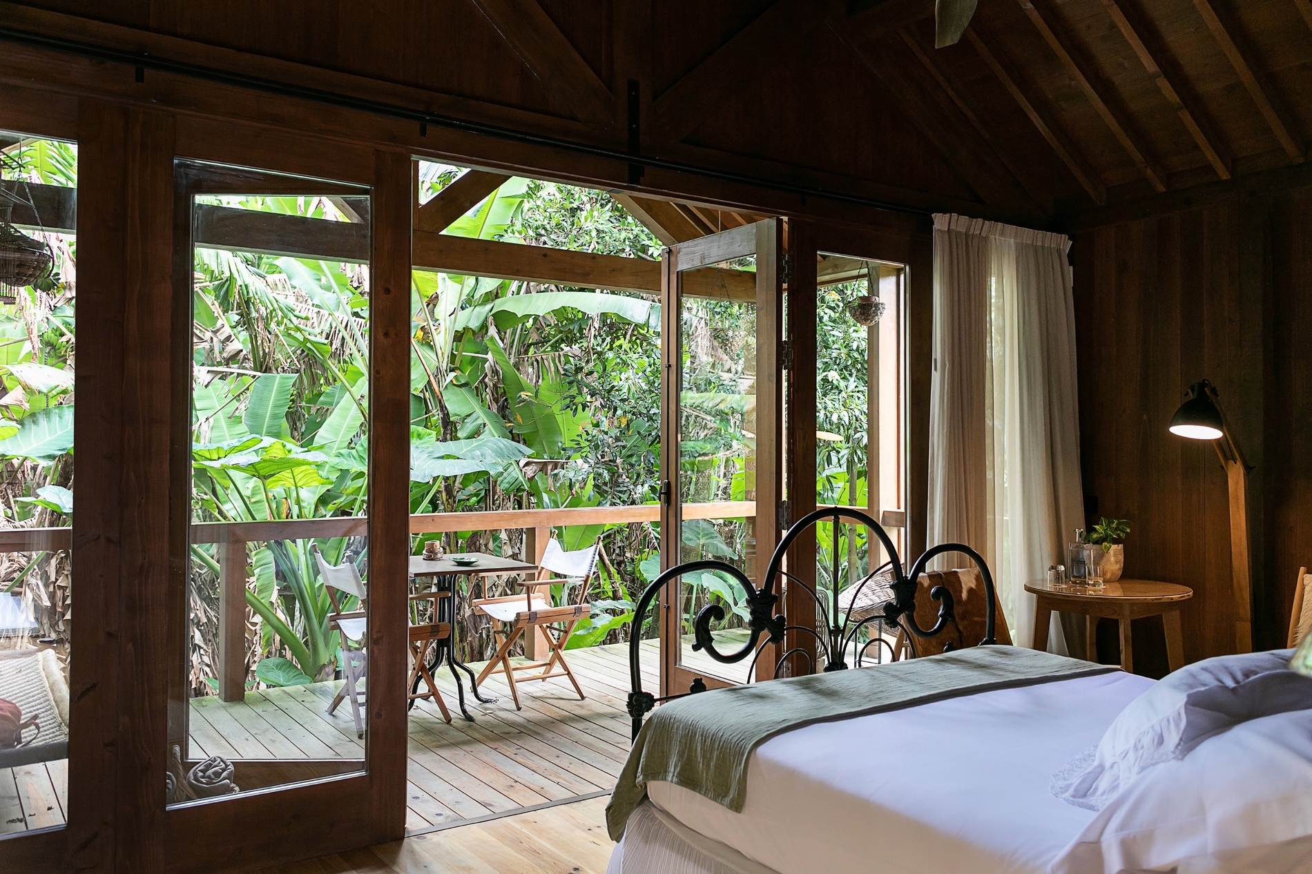 a bedroom with a bed and a balcony with a table and chairs