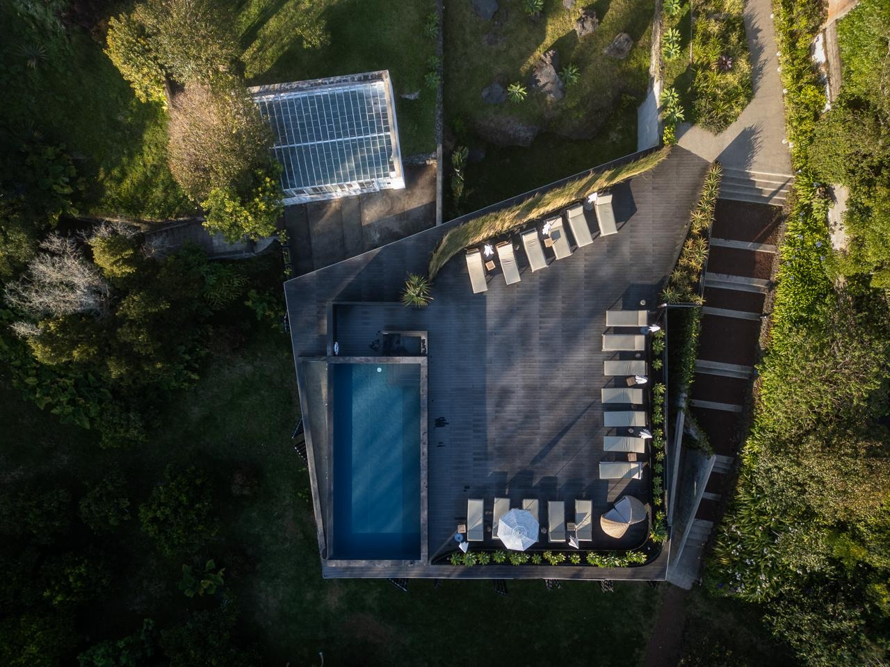 Piscina infinita com reflexos do céu e vegetação no Musgo Spa | Senhora da Rosa.