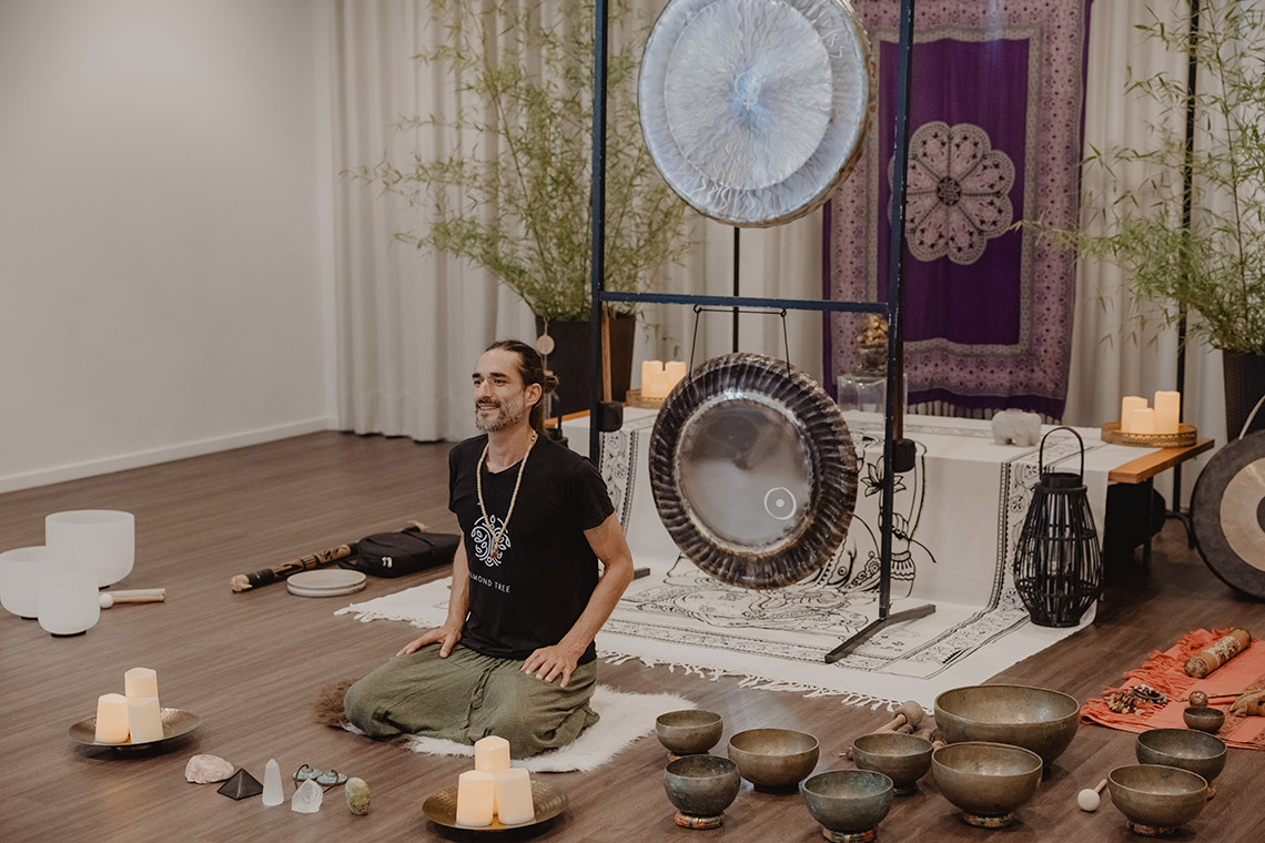 Man meditating with gongs and crystal bowls, perfect for Senhora da Rosa retreats.