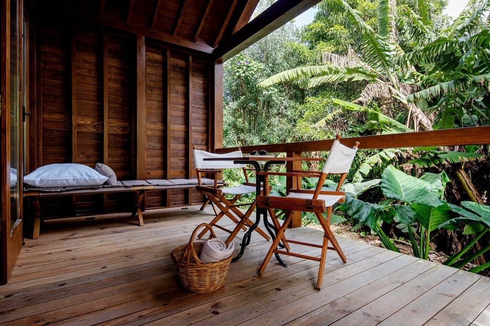 a wooden deck with two director 's chairs and a table