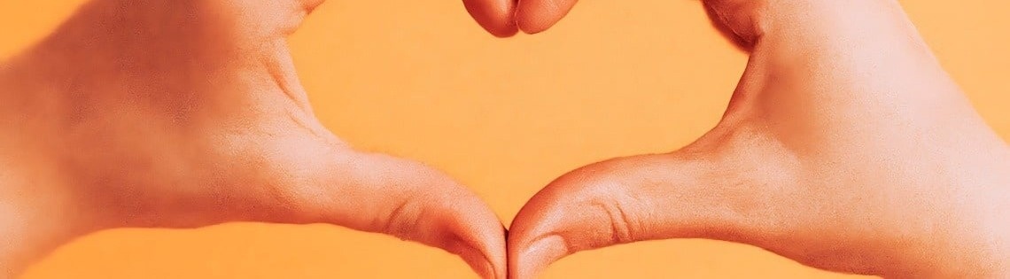 a person making a heart shape with their hands