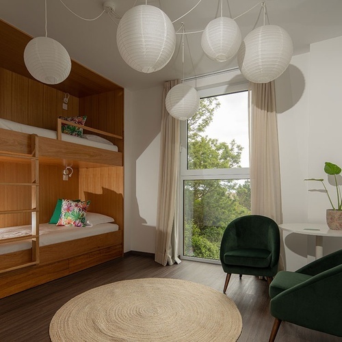 a bedroom with a bunk bed and a green chair