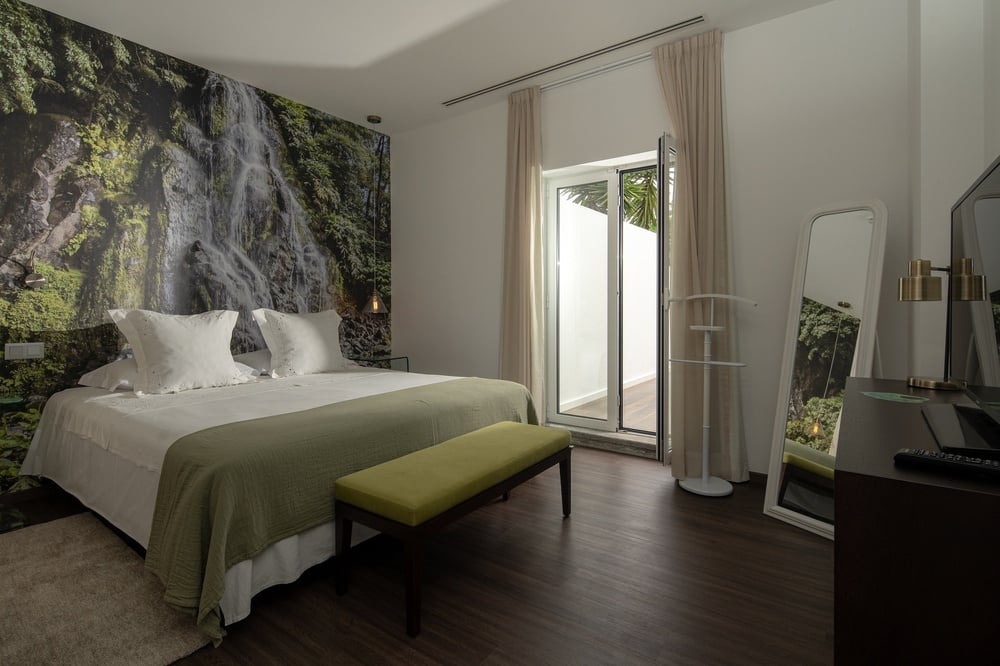 a bedroom with a waterfall wallpaper on the wall