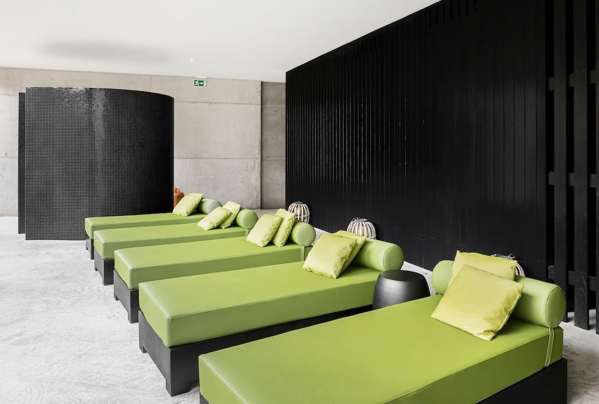 uma sala cheia de cadeiras verdes e almofadas amarelas