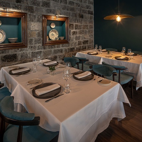 a dining room with tables and chairs and plates on the wall