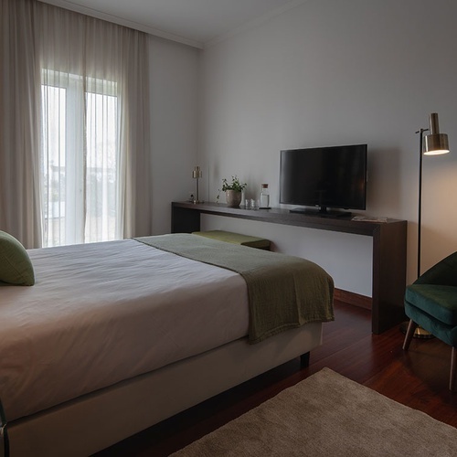 a bedroom with a large bed and a flat screen tv