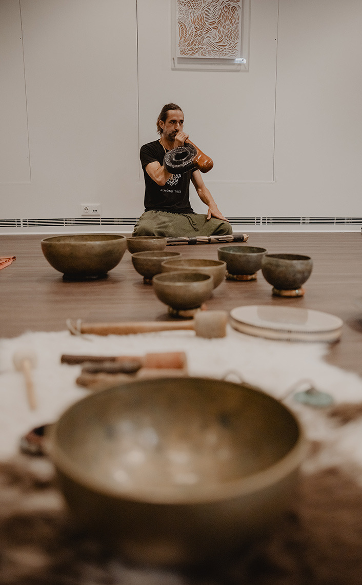 Man playing Senhora da Rosa in a room with meditation bowls.